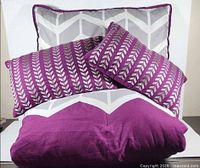 Comforter folded with sham and two throw pillows displayed