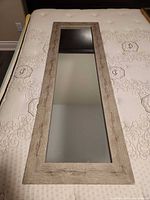 Full view of rectangular mirror on mattress
