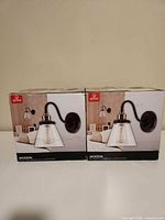 Front view of two boxed Globe Jackson wall sconces