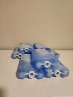 Eight blue plastic ice packs stacked
