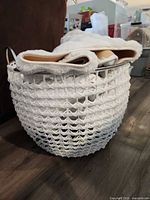 Full view of white plastic wicker basket with contents for scale