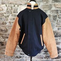 Front view of navy wool and brown leather varsity jacket on mannequin