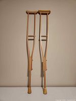 Full view of both wooden crutches leaning upright