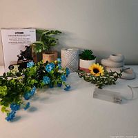 Group shot of boxed fountain, candle holders, faux plants, garland, LED pack