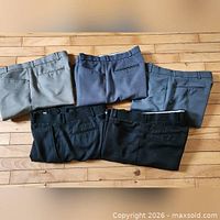 Five pairs folded showing waistbands and pockets