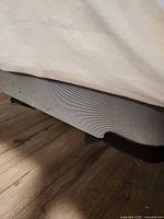 Side view of grey fabric covered twin box spring