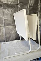 Front view of two folded white Table Mate II TV trays