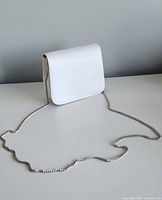 Front view of white satin purse with chain strap