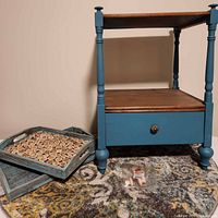 Front view of end table, trays, rug, spare knobs