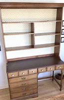 Front view of the farmhouse hutch showing shelves, drawers, and wallpapered back panel