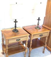 Two cherry wood nightstands with matching dark metal base table lamps with cream fabric shades on top, showing the overall look and finish.