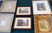 Six framed art pieces laid flat on blue fabric, includes botanical prints, architectural reproductions, signed numbered print, and ornate gold print