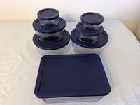 Top view of all Pyrex containers with lids arranged in two stacks and one rectangular container in front.