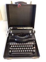 Front view of the vintage Remington Rand typewriter inside its open carrying case, showing keyboard and top panel with brand name.