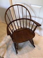 Front and top view of vintage barrel shaped wooden rocking chair showing spindle back and contoured seat.