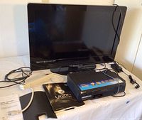 Vizio 37-inch flatscreen TV with Sony VHS player, manuals, remotes, and cables on a table