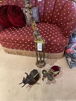 Wide shot showing all three animal decor pieces placed on carpet in front of couch: tall giraffe, camel with luggage, and elephant figure.