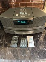 Front view of Bose Wave Radio/CD system with two remotes and auction card