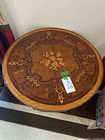 Top-down view of round tabletop showing floral and scroll marquetry design