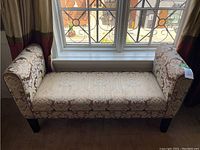 Front view of the hallway bench set against a window, showing full shape, armrests, and legs.