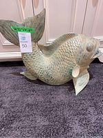 Full view of fish sculpture displayed on carpet in front of bathroom cabinets