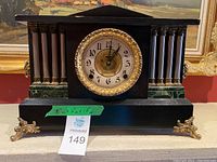 Full front view of black Ingraham mantel clock on table surface