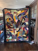 Full front view of quilt held up against background.
