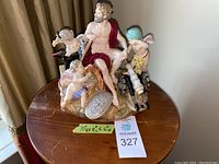 Full front view of the Meissen figurine on wooden table showing overall composition and scale