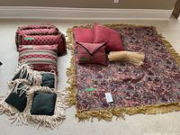 Overview of all pillows and table cover arranged on carpeted floor