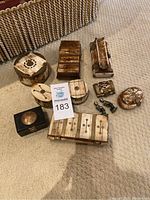 All nine trinket boxes and two small metal figurines arranged on carpet floor for overall view