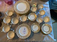 Top view of plates, cups and saucers arranged on table showing overall lot and pattern.