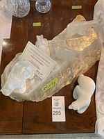 Overhead view of marble slab sculpture with three polar bears and separate white stone polar bear figurine alongside certificate of authenticity