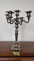Full view of antique candelabra showing five candle holders and overall ornate design.
