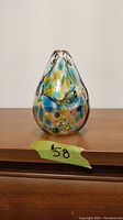Front view of the blown art glass vase showing colorful spotted patterns and open top.