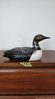 Side view of the ceramic loon figurine showing detailed hand-painted feathers and coloration.