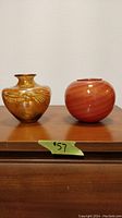 Both art glass vases side by side on a wooden surface, visible size approx 4 inches tall and wide.