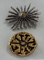 Top photo shows front side of two brooches, silver-toned with gold center, and gold-toned with black cutout design