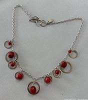 Full chain laid out on light surface showing all seven coral pendants