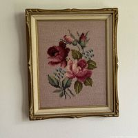 Full view of the framed vintage floral embroidery artwork on pink fabric backing.