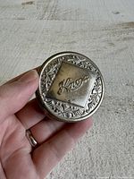 Closed Knox collapsible cup showing top embossed floral design and Knox logo