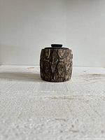 Front view of cylindrical wooden box showing natural Ponga wood grain and carved patterns