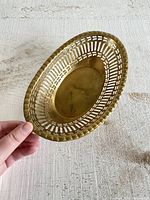 Top and side view of vintage small oval brass bowl with cutout design rim, showing size and shape.