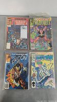 Four comic books shown in the lot including Machine Man #1, Hercules #1, The Falcon #1, and Iceman issue with character on ice cover. Bagged comics, mid-grade condition visible.