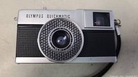 Front view of the Olympus EES Quickmatic camera showing lens and branding.