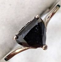Front view of ring showing triangular black diamond in three-prong setting