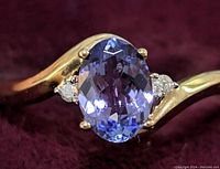 Front view close-up showing oval tanzanite center and side diamonds