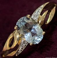 Front angle showing oval aquamarine and diamond-accented shoulders