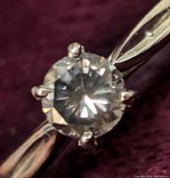 Close-up of round brilliant brown diamond solitaire in four-prong setting on white gold shank