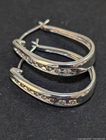 Pair of hoop earrings stacked and laid flat on black background