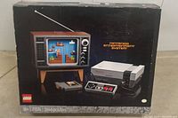 Front of original LEGO set box showing Nintendo Entertainment System console, retro TV, game cartridge, and controller